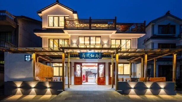 A modern hotel with a covered entrance, large windows, and a signboard. - Zhouzhuang Hefeng Xiyu Inn (Kunshan)