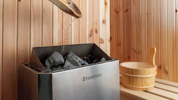 Eine Steamtec Sauna mit Holzeinrichtung und einem Holz-Eimer.
