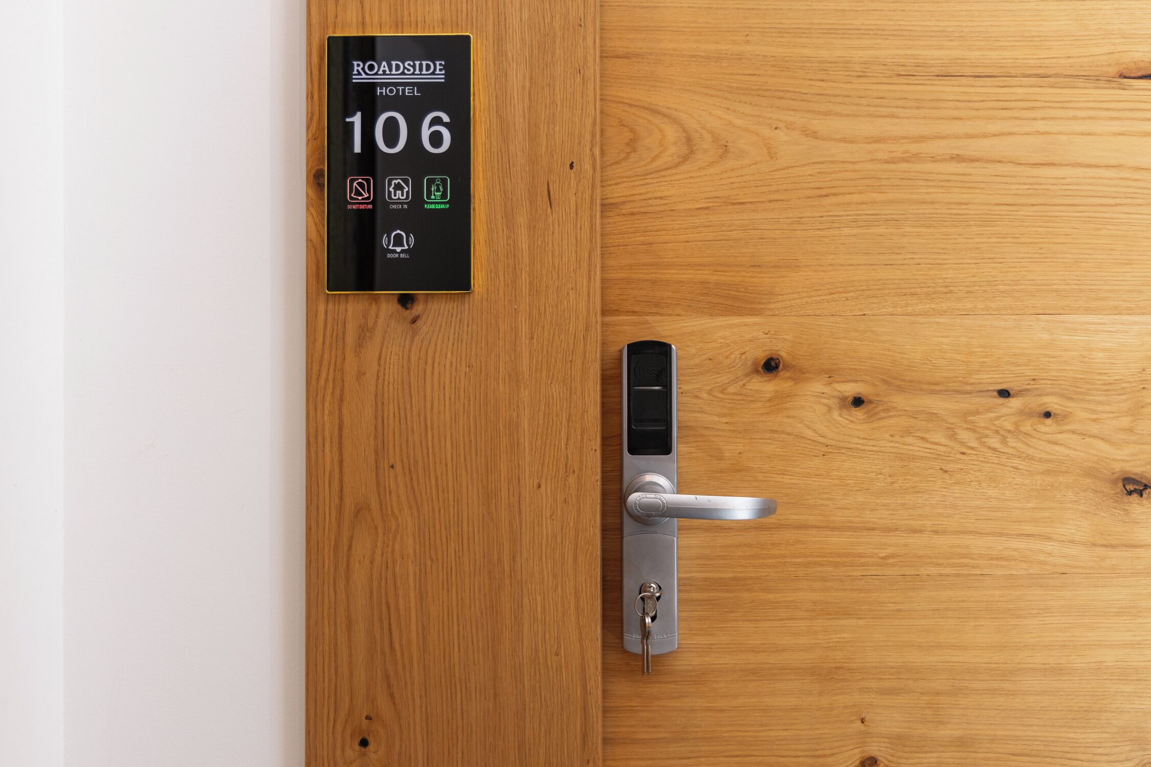 A hotel room door with a digital lock and a sign indicating room number 106.