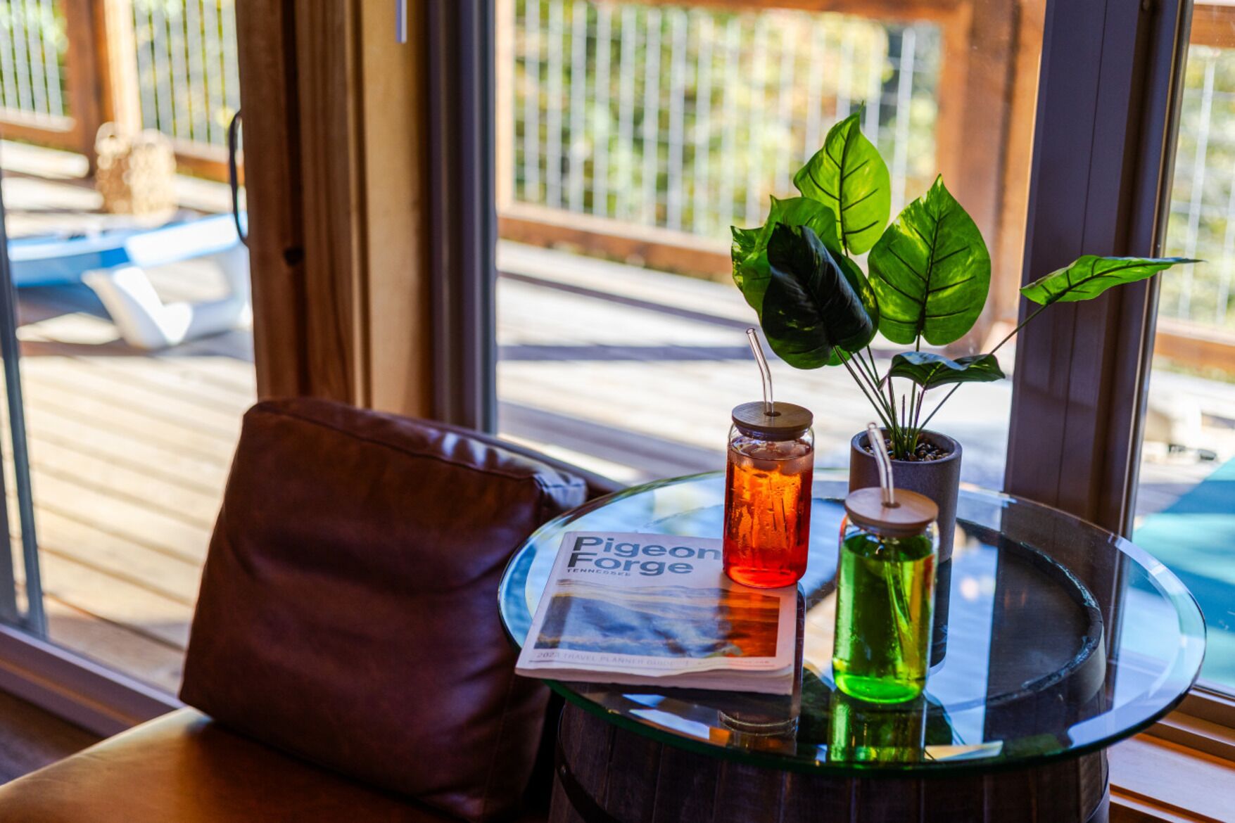 A glass table with a newspaper, a glass bottle, and a potted plant.