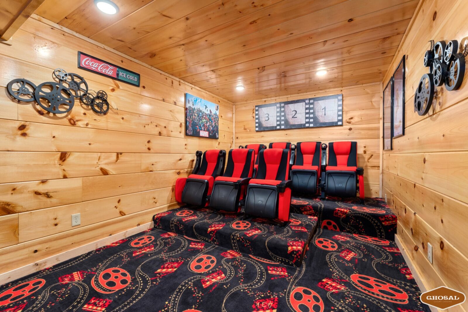Un sauna con paredes de madera, asientos negros y rojos, un cartel de Marvel y un letrero de Coca-Cola.