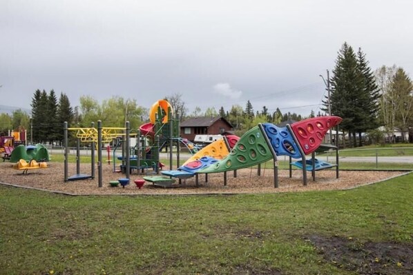 A playground with various play structures including slides and climbing areas.