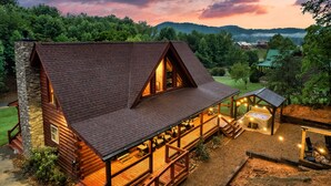 A log cabin with a large deck, a hot tub, and a covered seating area. - Newly Renovated! Fishing, Full Game Rm, Hot Tub! (Sevierville)
