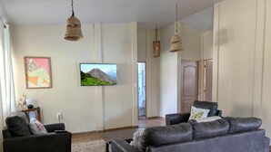 Un soggiorno con divano, televisore e un elemento decorativo a parete.