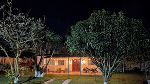 Una casa con un prato curato, un vialetto che conduce all'ingresso e un portico con posti a sedere all'aperto.