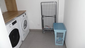 A laundry area with a washing machine, a drying rack, and a laundry basket. - La Villa « Jules Verne » à Saint Firmin - Le Crotoy, au Cœur de la Baie de Somme (Le Crotoy)