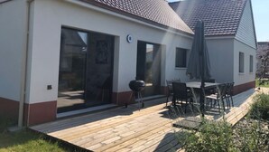 A modern house with a patio, a barbecue grill, and a dining area. - La Villa « Jules Verne » à Saint Firmin - Le Crotoy, au Cœur de la Baie de Somme (Le Crotoy)