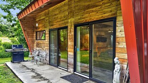 A wooden exterior with sliding glass doors, a barbecue grill, and outdoor seating. - Nordic Eco House - Black Mountain (Black Mountain)