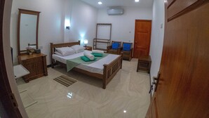 A bedroom with a bed, bedside tables, a mirror, a wardrobe, and a door. - Innovick Residence (Kandy)