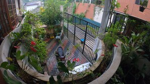 A balcony with a view of a river, surrounded by greenery and a brick wall. - Innovick Residence (Kandy)