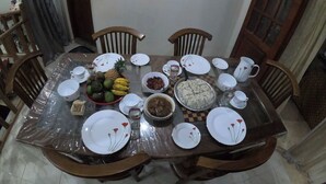 A dining table set with plates, bowls, and a fruit bowl. - Innovick Residence (Kandy)