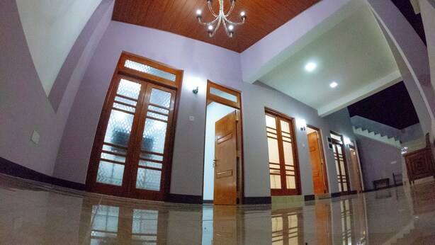 A spacious interior with a polished floor, wooden doors, and a chandelier. - Innovick Residence (Kandy)