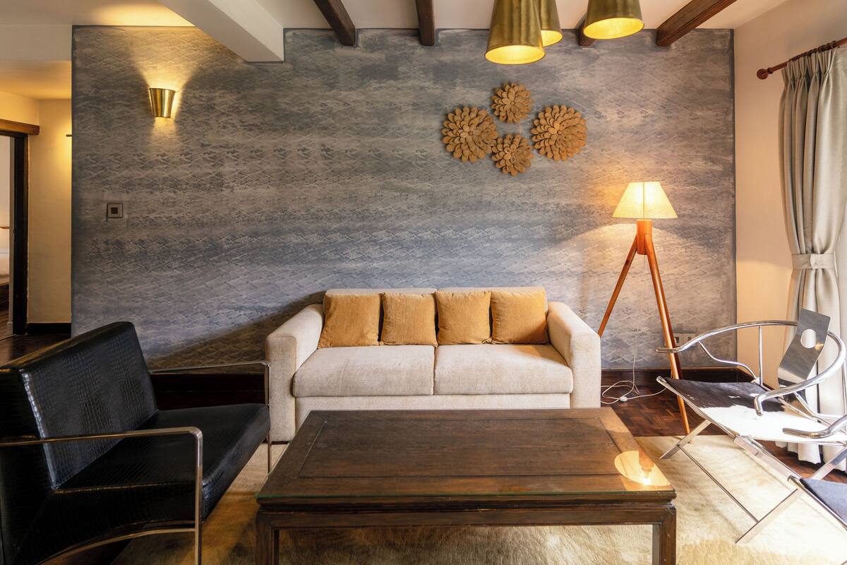 A modern living room with a sofa, a coffee table, and a lamp.