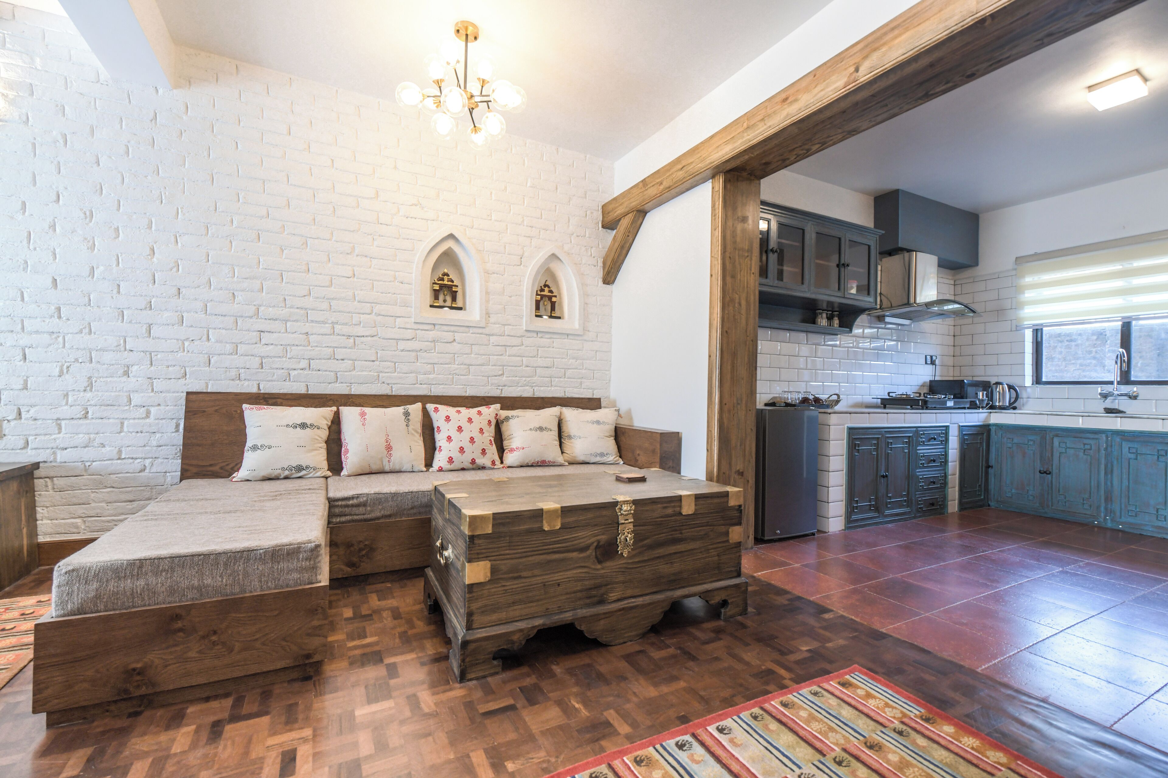 Een gezellige kamer met een houten bankje, een dressoir en een metselwerk muur.