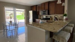 A spacious kitchen with a large island, wooden cabinets, and pendant lighting. - Private pool-Comfy home- 8 guest

 (Davenport)