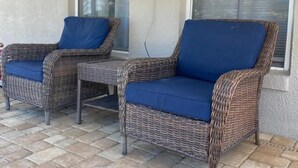 A patio area with wicker furniture and a table, featuring large windows and a tiled floor. - Private pool-Comfy home- 8 guest

 (Davenport)