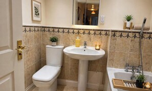 Een badkamer met toilet, wastafel en bad.