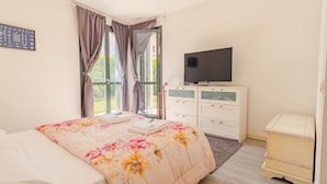 A bedroom with a bed, a TV on a dresser, and a window with curtains. - Lugana Lovers - Italian Homing (Sirmione)
