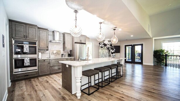 A spacious kitchen with a large island, bar stools, and modern appliances.