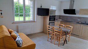 Una cocina moderna con comedor, sofá y televisor.