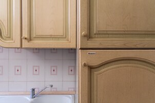 Una cucina con mobili impiallacciati in legno e un lavello.