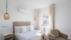 A modern hotel room with a large bed, a bedside table, a chair, and a window with curtains.