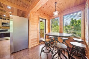 A wooden interior with a kitchen, dining area, and large windows. - Pigeon Forge I Hot tub I Theatre I Walk to Parkway (Pigeon Forge)