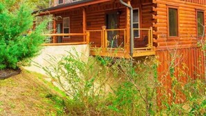 A two-story log cabin with a balcony and a covered porch. - Pigeon Forge I Hot tub I Theatre I Walk to Parkway (Pigeon Forge)