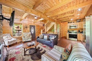 A cozy cabin interior with a living room, kitchen, and a staircase. - Pigeon Forge I Hot tub I Theatre I Walk to Parkway (Pigeon Forge)
