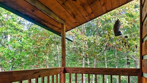 A wooden deck with a hot tub, surrounded by lush greenery and trees. - Views I Between Pigeon Forge Gatlinburg I Firepit (Sevierville)