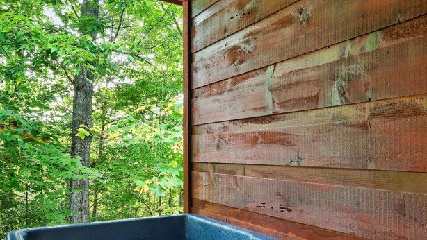 A hot tub with a view of a forest.