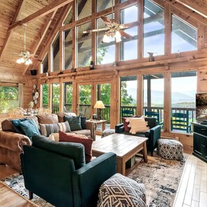 Relax in a spacious room with expansive views, a plush sofa set, and a central table, surrounded by a mix of contemporary and classic decor.