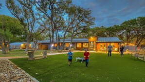 Una casa moderna con un césped cuidado y árboles.