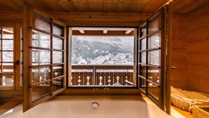 A wooden cabin with a large window and a wooden deck. - New in Grindelwald-Chalet Caramelle, Top of Grindelwald (Grindelwald)