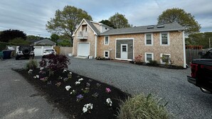 A two-story house with a garage, a fenced yard, and a gravel driveway.