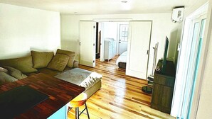 A compact living space with a kitchenette, a sofa, and a dining area.