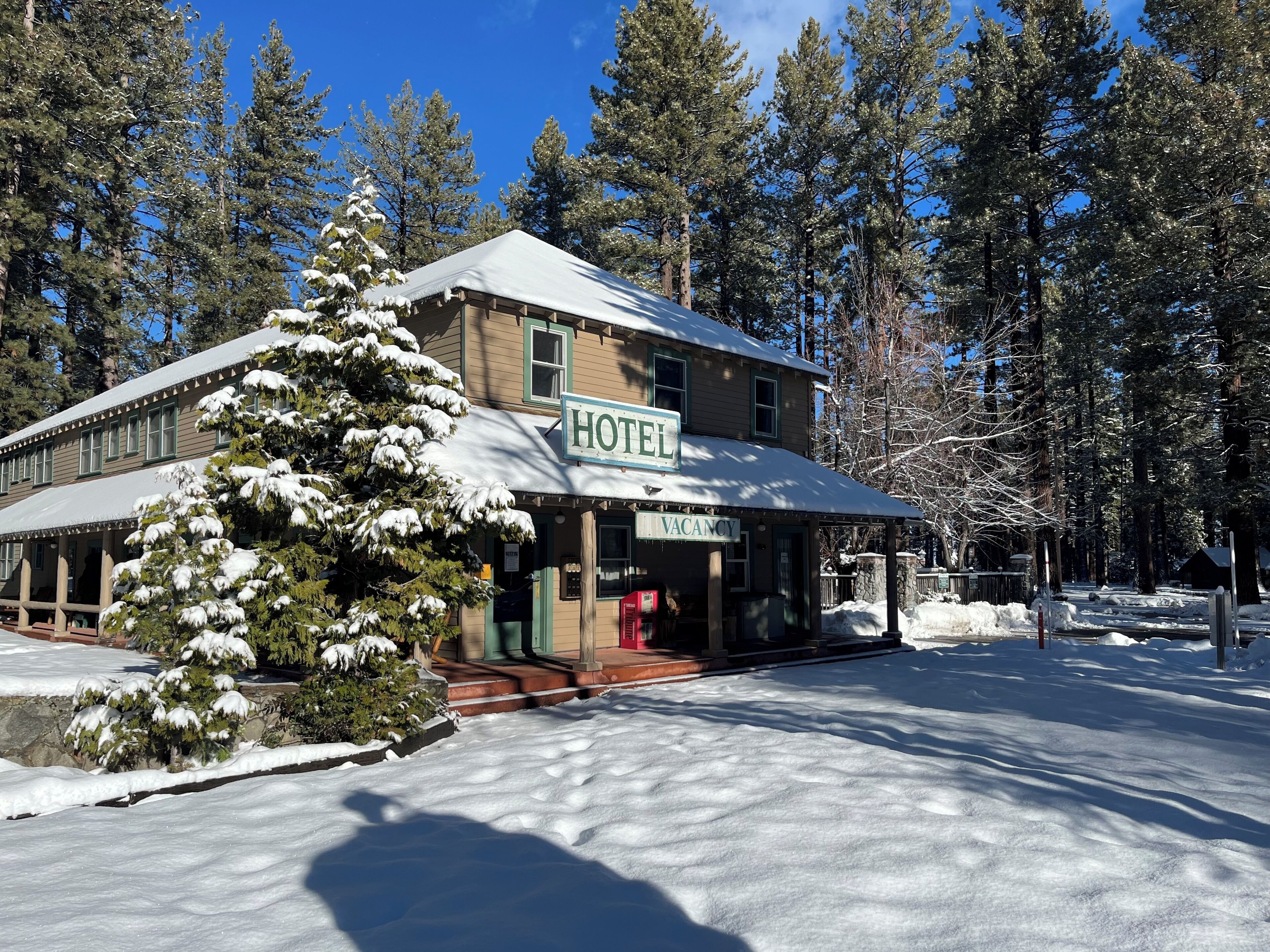 Ett hotell med ett snötäckt tak och en skylt som visar att det finns lediga rum.