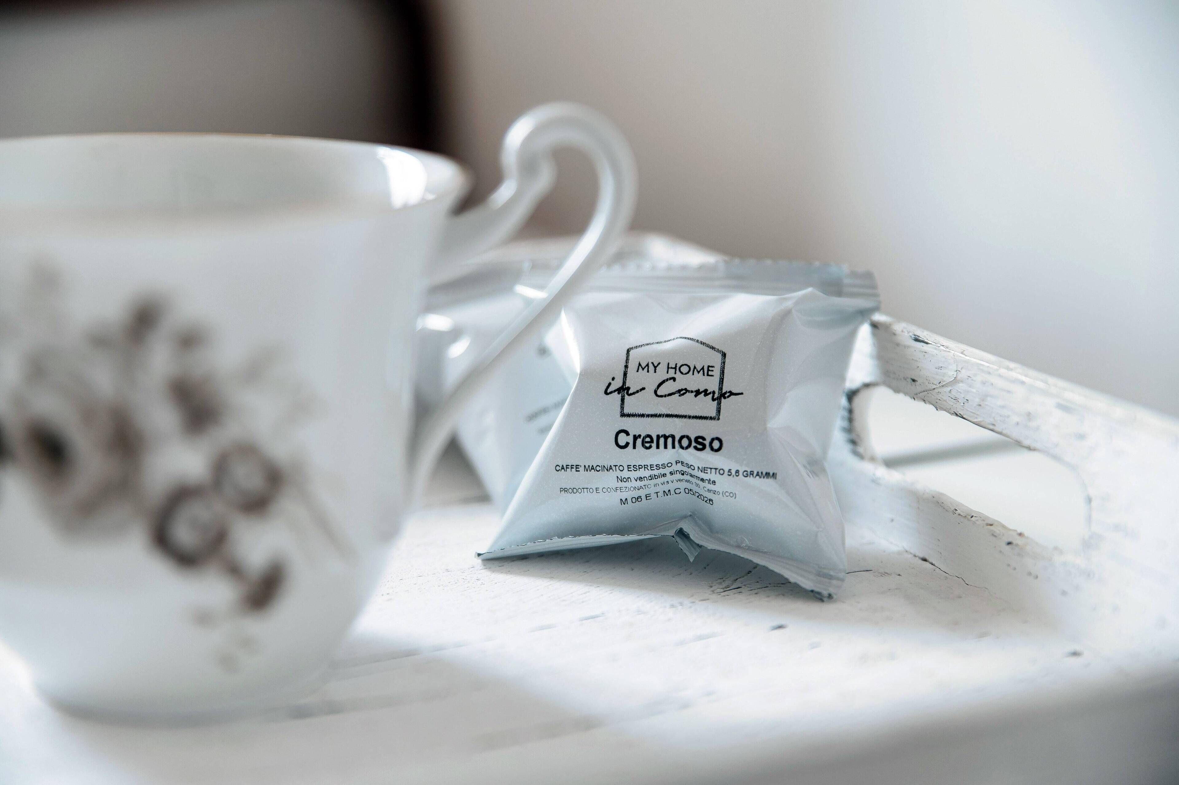Een witte keramische kop en een pakje Cremoso espresso op een witte schaal.