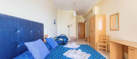 Un dormitorio con una cama grande, un escritorio y una silla.