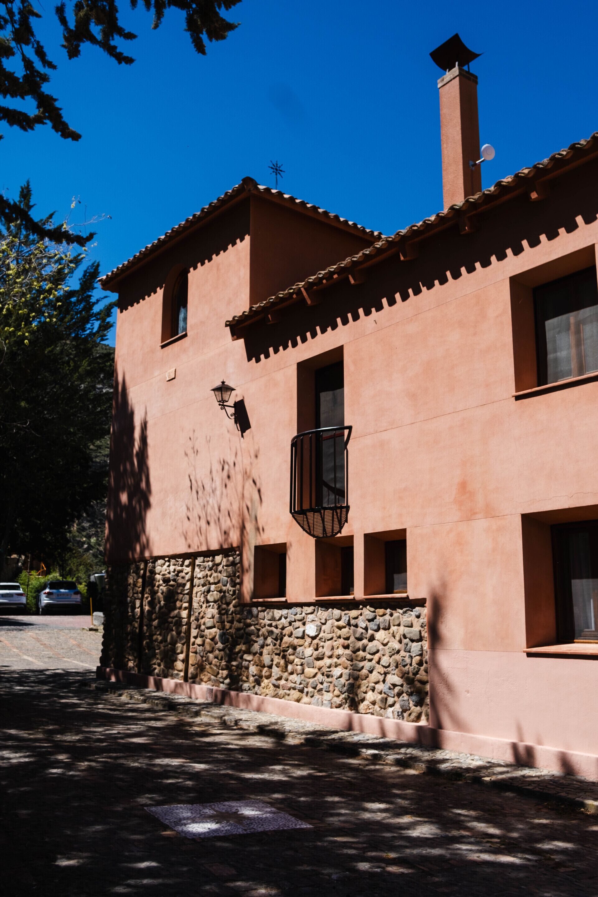 A two-story building with a stone foundation and a reddish-brown facade.