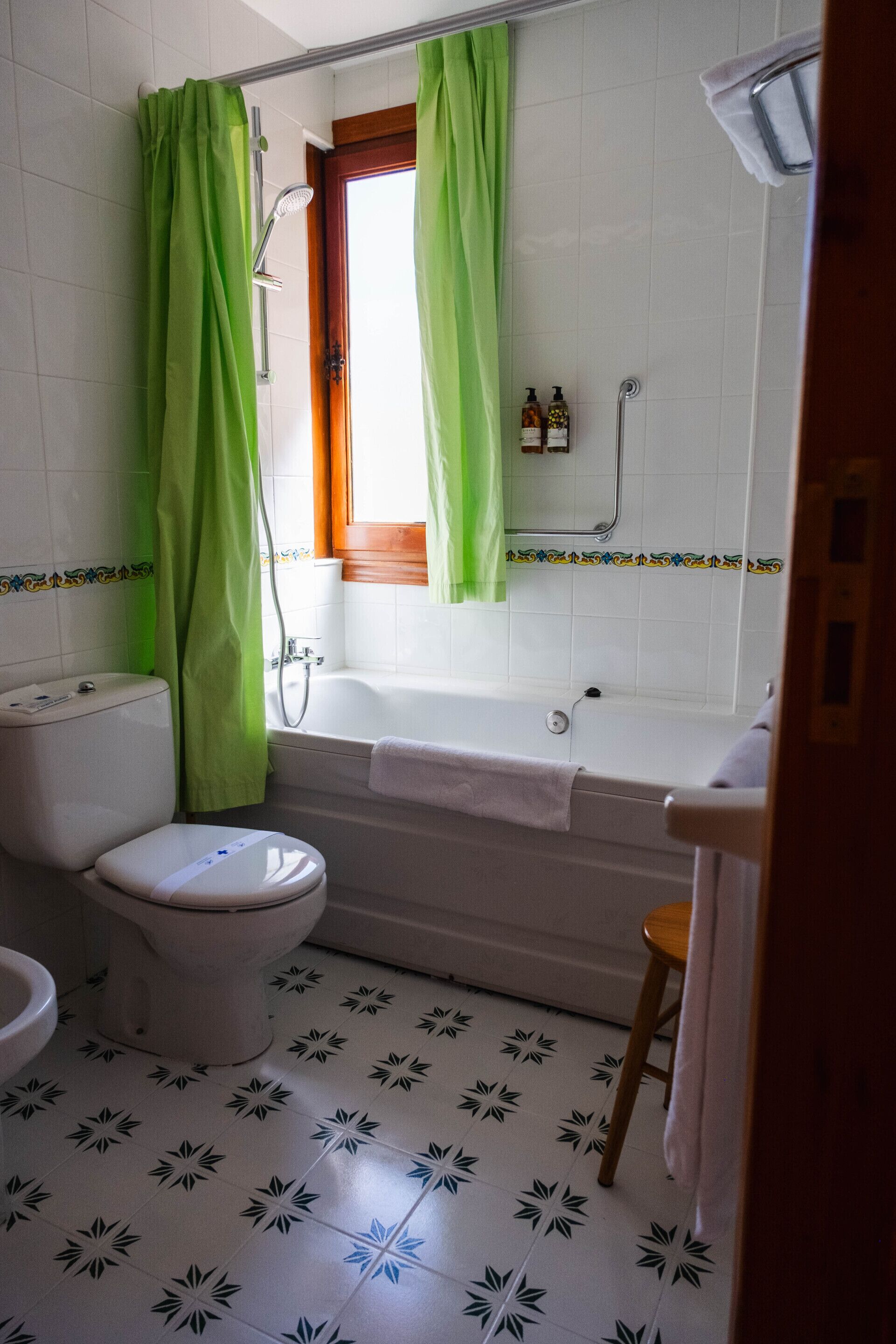 A bathroom with a toilet, bathtub, and shower curtain.
