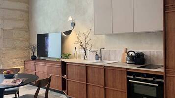 Una cucina moderna con mobili in legno, forno integrato e zona pranzo con tavolo e sedie.