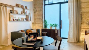 A modern living room with a round table, a sofa, and a large window with a view.
