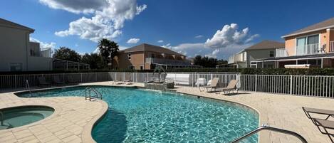A swimming pool with a 3 ft. depth marker, surrounded by lounge chairs and a fence.