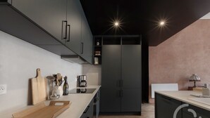 A modern kitchen with grey cabinets, a wooden countertop, and a built-in oven. - Bel Appartement de 110m2 Dans un Hôtel Particulier du Xviiie Siècle (Salins-les-Bains)