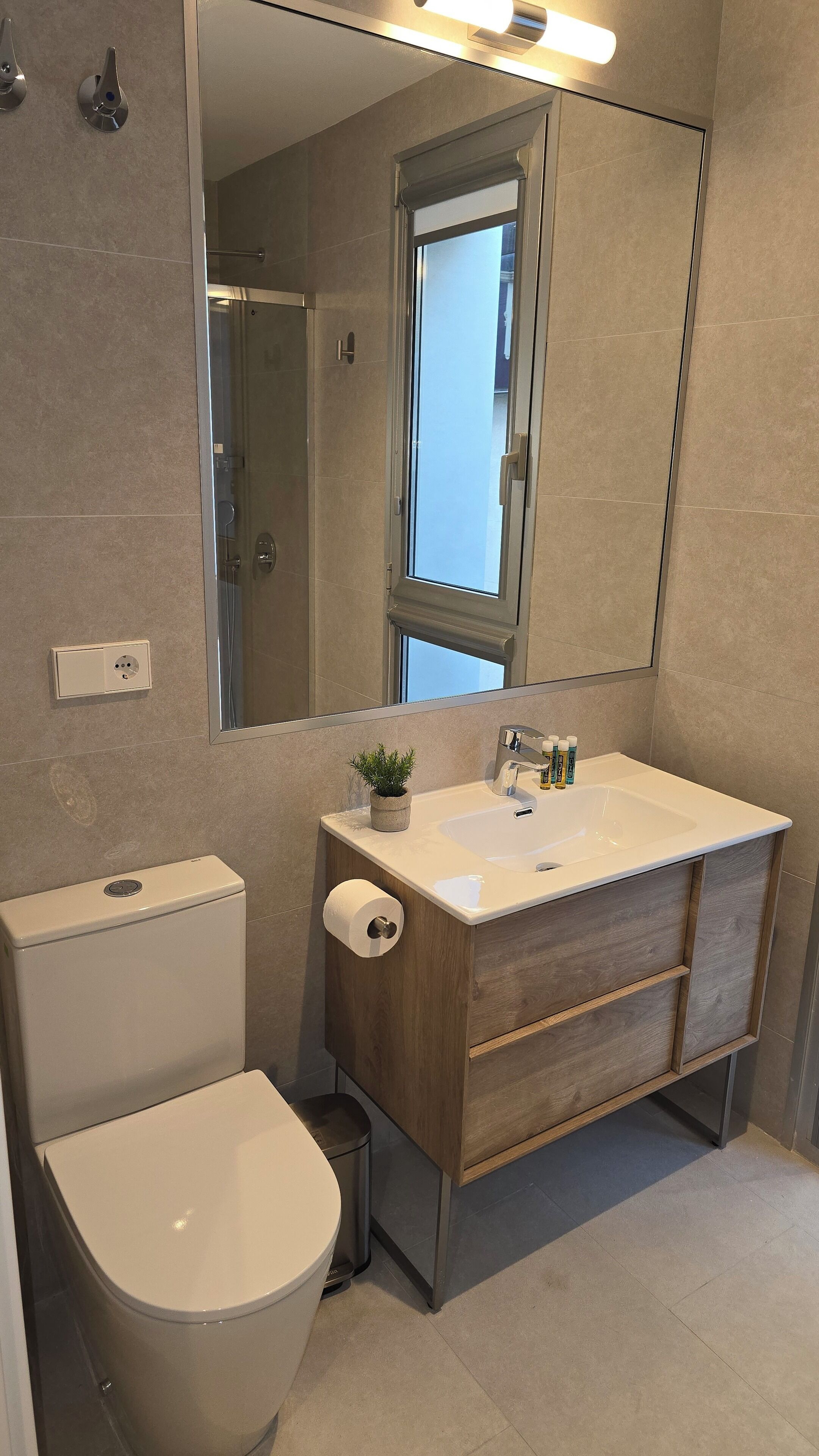 A bathroom with a toilet, sink, and shower.