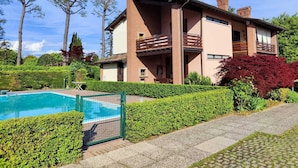 A two-story house with a swimming pool, surrounded by well-maintained hedges and trees. - Your nest in Manerba (manerba del garda)