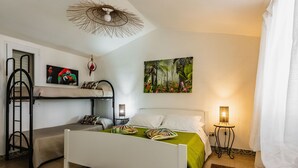 A bedroom with a bunk bed, a single bed, a painting, and two bedside lamps. - Galatea 4 by Wonderful Italy (Avola)