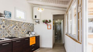 A modern kitchen with dark wooden cabinets, a tiled backsplash, and a window with a view. - Galatea 4 by Wonderful Italy (Avola)