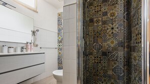 Un baño con ducha, inodoro y lavamanos.